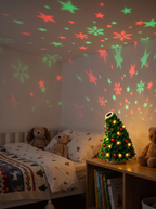 Festive star patterns on a child's bedroom ceiling from the Fir Mini Christmas Tree Projector Light