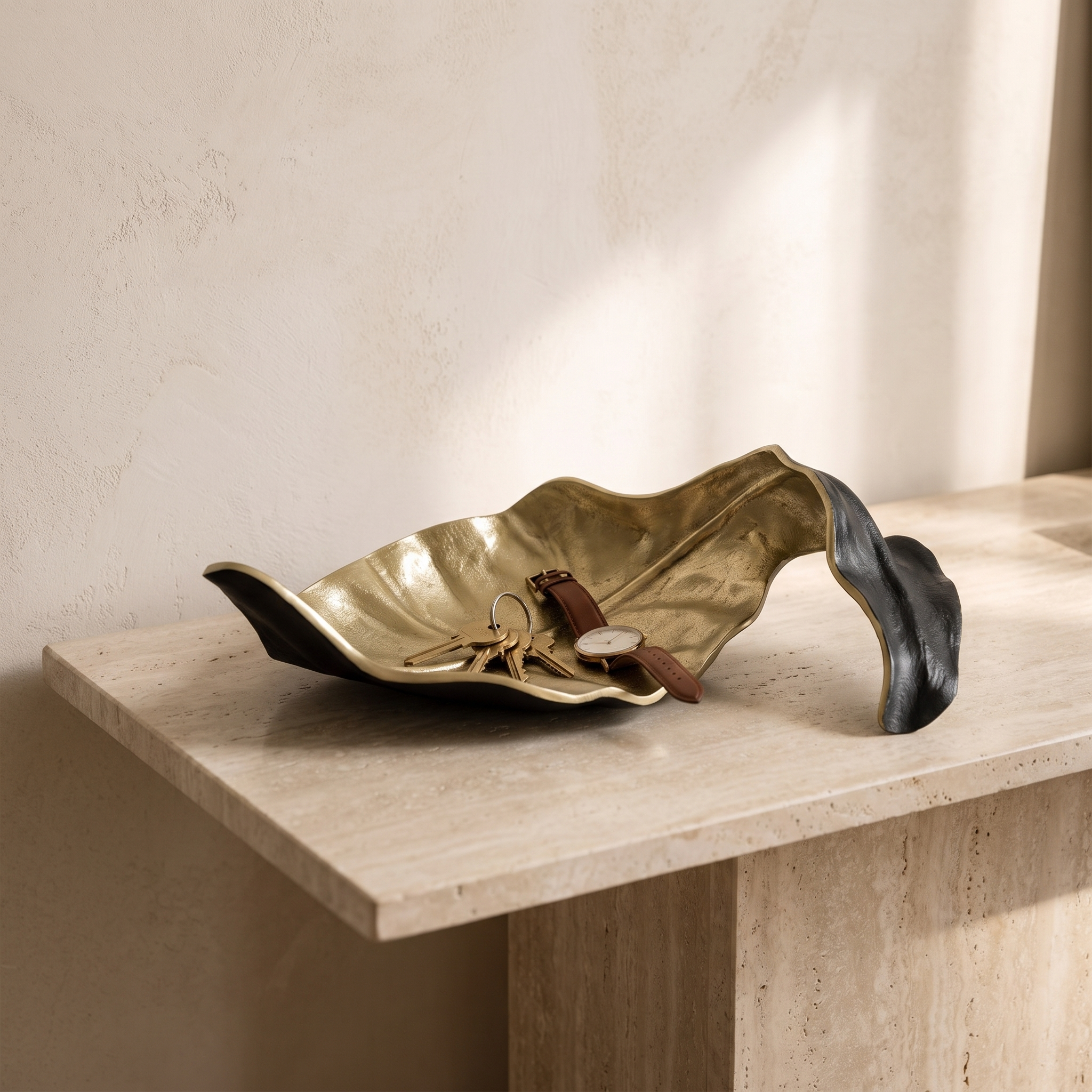 Fern leaf tray on an entryway console holding keys and a watch