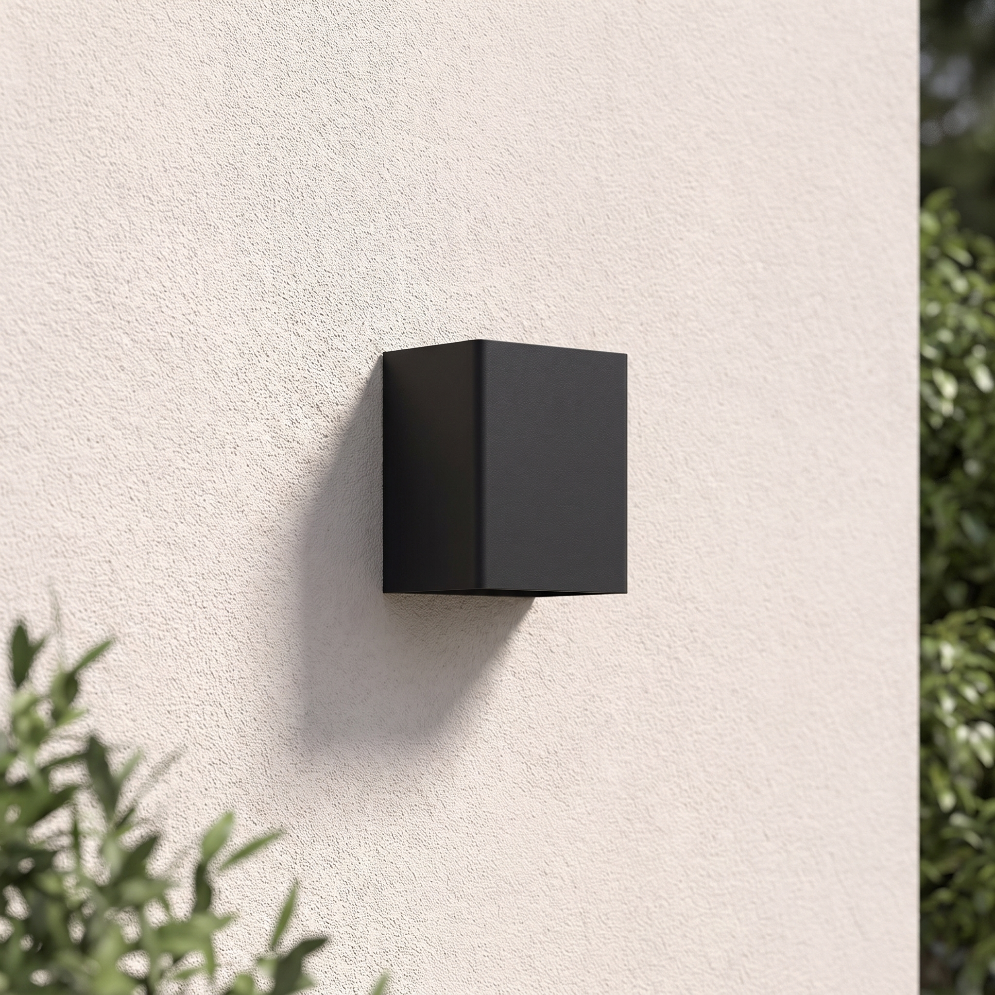 Beacon wall light in black mounted on a garden wall in daylight