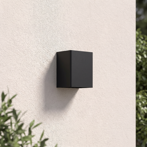 Beacon wall light in black mounted on a garden wall in daylight