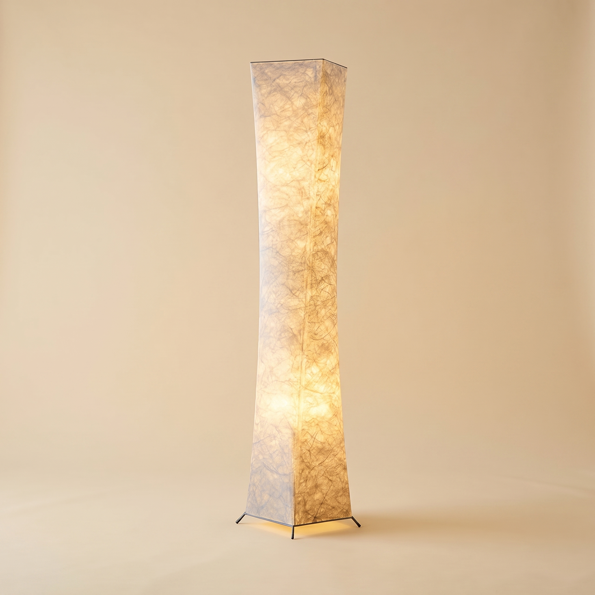 Vesper floor lamp switched on, full length against a sand coloured backdrop